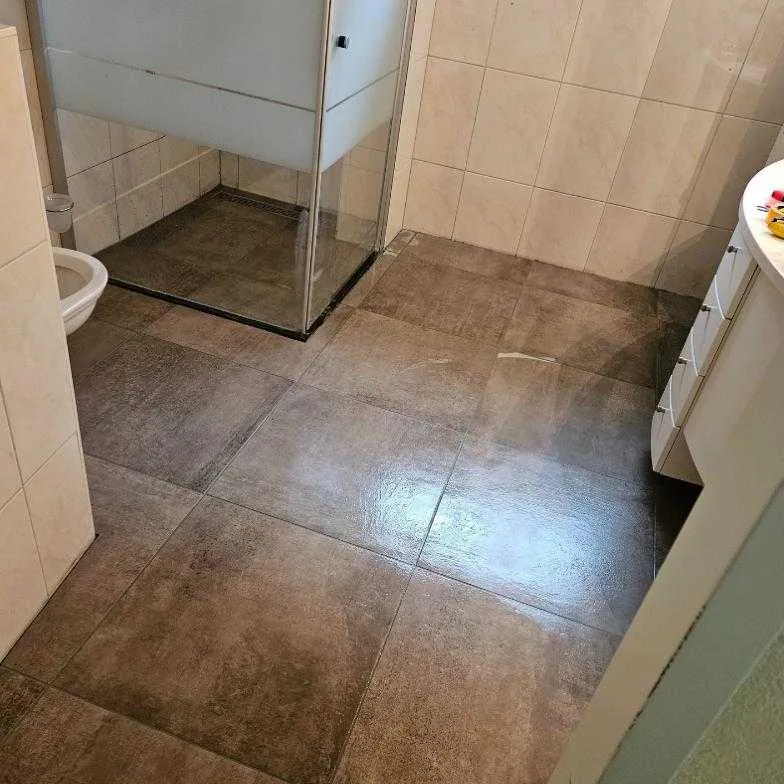 Badkamer met nieuwe vloertegels na het herstel