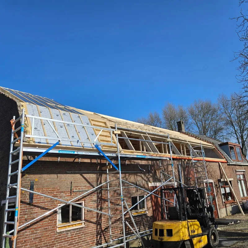 Woning met nieuw houten dakbeschot op de kap, met steigers langs de gevel