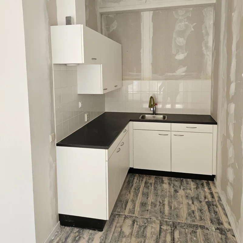 Nieuwe witte keuken in een ruimte die nog wordt afgewerkt