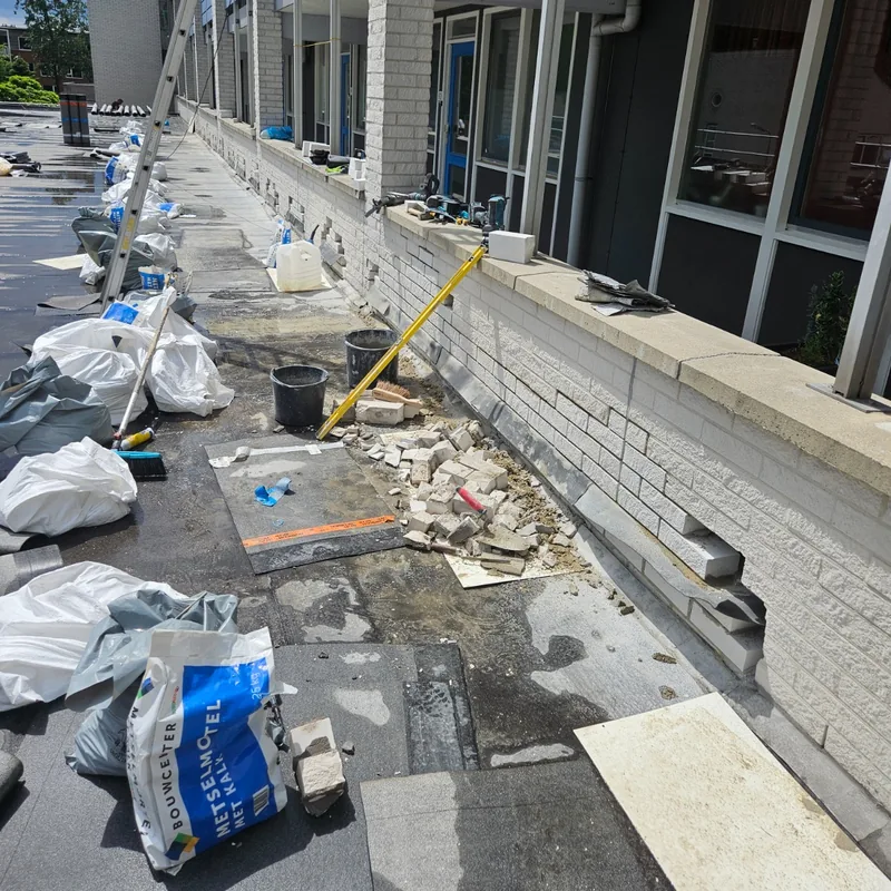 Onderste lagen metselwerk in delen uitgehakt voor het loodwerk