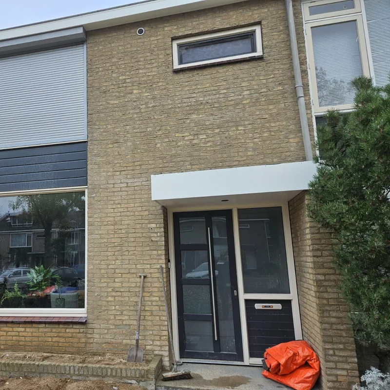 Woning met een nieuwe witte luifel boven de voordeur